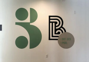 Green and black B on white wall